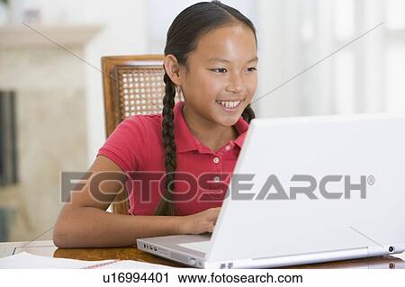 Young girl with laptop in dining room smiling View Large Photo Image Stock Image - Young girl with laptop in dining room smiling. Fotosearch