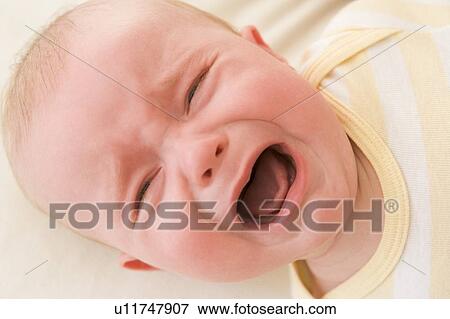 Baby lying indoors crying View Large Photo Image Stock Photo - Baby lying indoors crying. Fotosearch