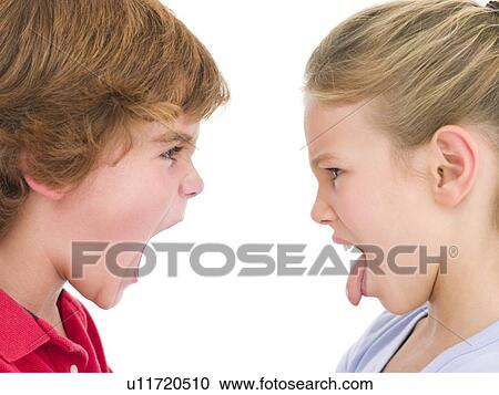 Stock Image - Brother shouting at sister sticking her tongue out. Fotosearch