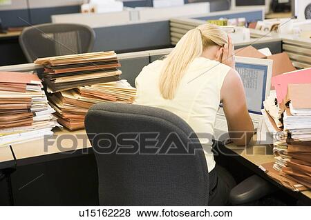 Businesswoman in cubicle with laptop and stacks of files View Large Photo Image Stock Photo - Businesswoman in cubicle with laptop and stacks of files. Fotosearch