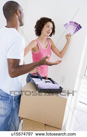 Couple with paint swatches in new home undecided View Large Photo Image Stock Photo - Couple with paint swatches in new home undecided. Fotosearch