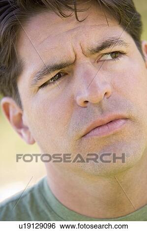 Stock Photograph - Head shot of man scowling. Fotosearch