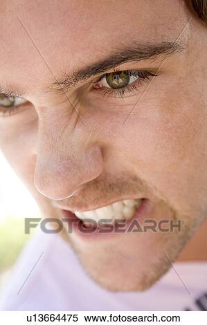 Stock Photography - Head shot of man scowling. Fotosearch