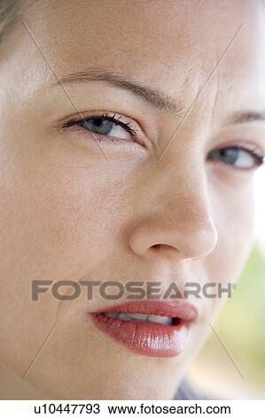 Stock Image - Head shot of woman scowling. Fotosearch