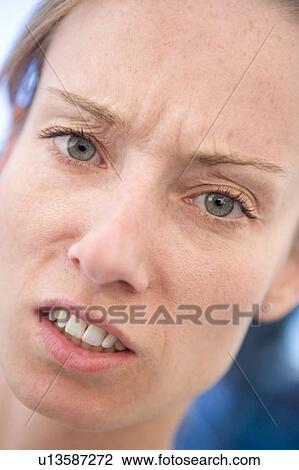 Stock Image - Head shot of woman scowling. Fotosearch