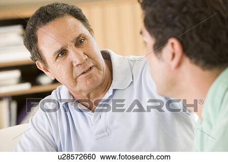 Two men in living room talking View Large Photo Image Stock Image - Two men in living room talking. Fotosearch
