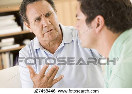 Two men in living room talking View Large Photo Image Stock Photograph - Two men in living room talking. Fotosearch