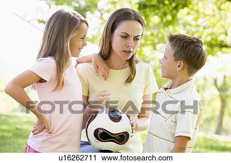 Woman and two young children outdoors holding volleyball and smiling View Large Photo Image Stock Image - Woman and two young children outdoors holding volleyball and smiling. Fotosearch
