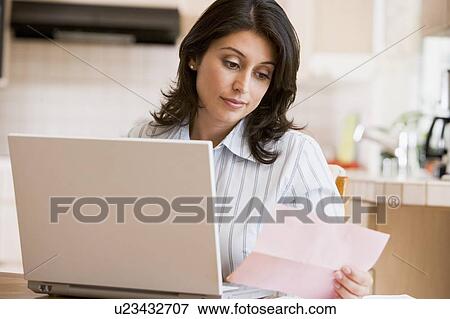 Woman in kitchen with laptop View Large Photo Image Stock Photo - Woman in kitchen with laptop. Fotosearch