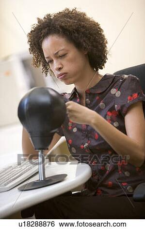 Woman sitting in computer room punching a small punching bag View Large Photo Image Stock Photograph - Woman sitting in computer room punching a small punching bag. Fotosearch