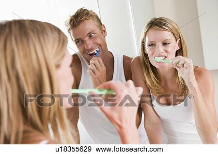 Stock Photo - Couple in bathroom brushing teeth. Fotosearch