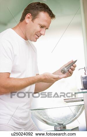 Man in bathroom applying aftershave View Large Photo Image Stock Image - Man in bathroom applying aftershave. Fotosearch