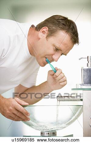 Man in bathroom brushing teeth View Large Photo Image Stock Photography - Man in bathroom brushing teeth. Fotosearch