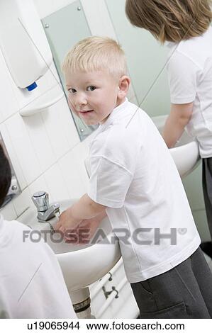 Picture - Students in bathroom at sinks washing hands. Fotosearch