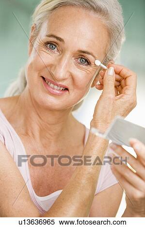 Woman applying eye makeup and smiling View Large Photo Image Stock Photography - Woman applying eye makeup and smiling. Fotosearch
