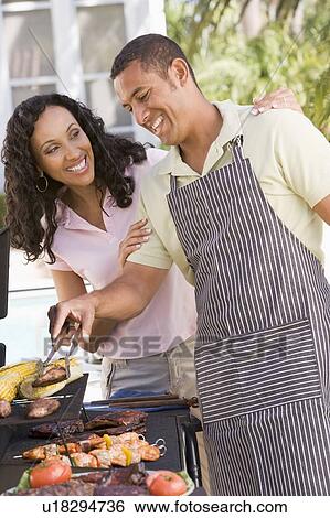 Stock Photograph - Couple Cooking On A Barbeque. Fotosearch