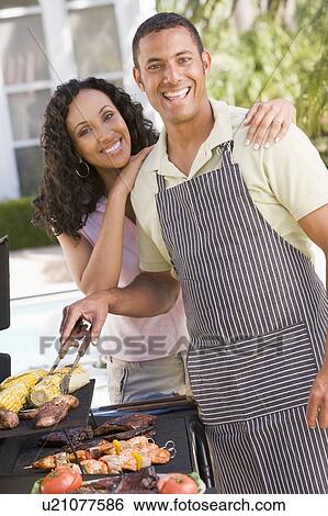 Stock Photograph - Couple Cooking On A Barbeque. Fotosearch