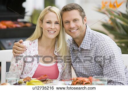 Stock Photograph - Couple Enjoying A Barbequed Meal In The Garden. Fotosearch