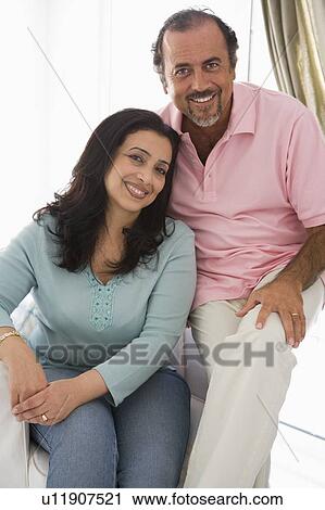 Couple in living room smiling (high key) View Large Photo Image Stock Image - Couple in living room smiling (high key). Fotosearch