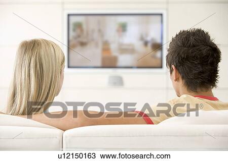 Couple in living room watching television View Large Photo Image Stock Image - Couple in living room watching television. Fotosearch