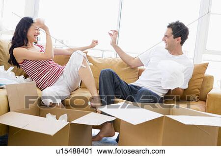Couple playfully unpacking boxes in new home smiling View Large Photo Image Stock Image - Couple playfully unpacking boxes in new home smiling. Fotosearch