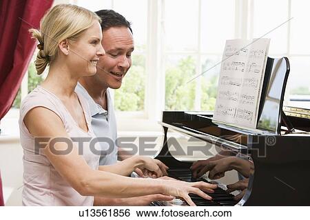 Stock Photograph - Couple playing piano and smiling. Fotosearch
