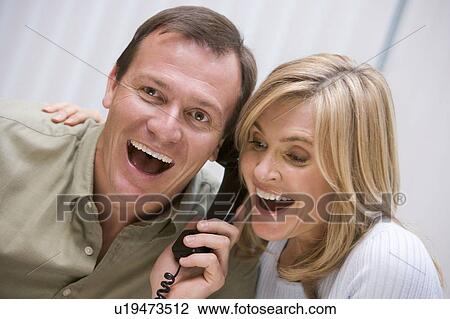 Couple receiving a good news phone call from clinic View Large Photo Image Stock Image - Couple receiving a good news phone call from clinic. Fotosearch