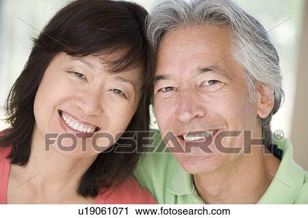 Couple relaxing indoors and smiling View Large Photo Image Stock Image - Couple relaxing indoors and smiling. Fotosearch