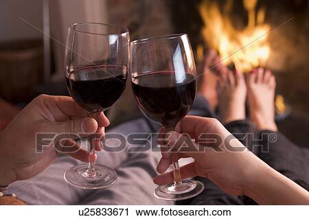 Feet warming at fireplace with hands holding wine View Large Photo Image Stock Image - Feet warming at fireplace with hands holding wine. Fotosearch