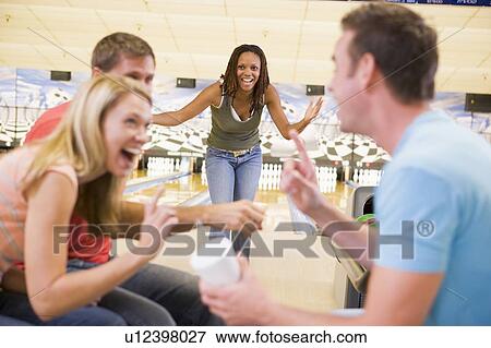 Stock Photo - Woman bowling with friends. Fotosearch