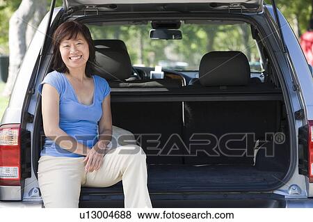 Woman sitting in back of van smiling View Large Photo Image Stock Photo - Woman sitting in back of van smiling. Fotosearch