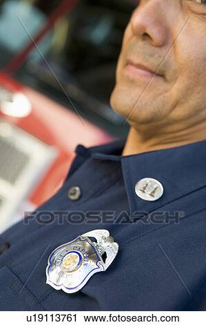 Fire captain with badge standing near fire engine (selective focus) View Large Photo Image Stock Image - Fire captain with badge standing near fire engine (selective focus). Fotosearch