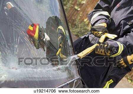 Firefighter cutting out a windshield after an accident View Large Photo Image Stock Photograph - Firefighter cutting out a windshield after an accident. Fotosearch