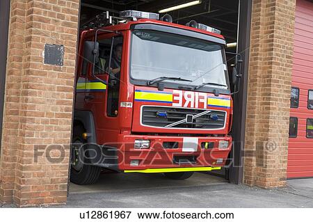 Firefighters driving fire engine out of the firehouse View Large Photo Image Stock Photo - Firefighters driving fire engine out of the firehouse. Fotosearch