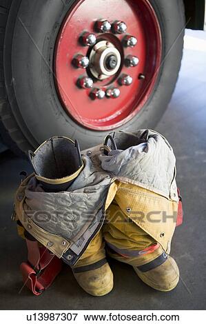 Stock Photo - Firefighting uniform on floor near fire engine. Fotosearch