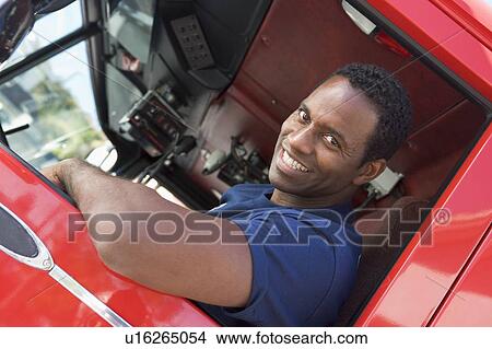 Picture - Fireman in driver's seat of fire engine. Fotosearch