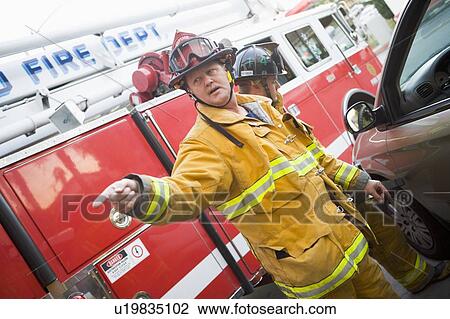 Fireman pointing at something with another fireman using the jaws of life on a car door View Large Photo Image Stock Image - Fireman pointing at something with another fireman using the jaws of life on a car door. Fotosearch
