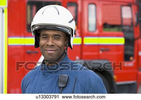 Fireman standing by fire engine wearing helmet View Large Photo Image Stock Image - Fireman standing by fire engine wearing helmet. Fotosearch