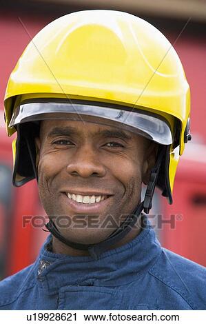 Fireman standing by fire engine wearing helmet View Large Photo Image Stock Image - Fireman standing by fire engine wearing helmet. Fotosearch
