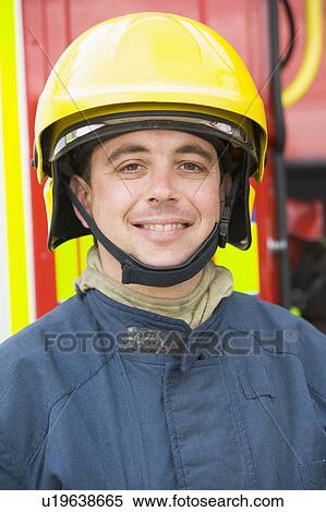 Fireman standing by fire engine wearing helmet View Large Photo Image Stock Photography - Fireman standing by fire engine wearing helmet. Fotosearch