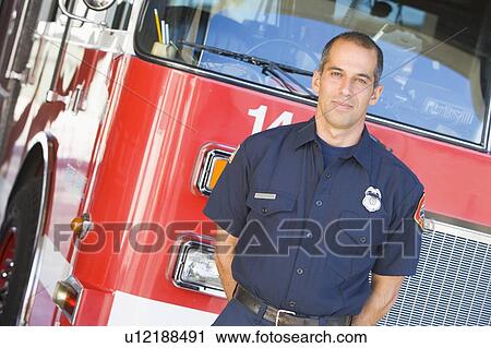 Fireman standing in front of fire engine View Large Photo Image Stock Image - Fireman standing in front of fire engine. Fotosearch
