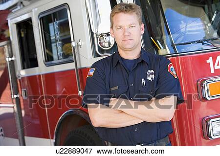 Stock Photo - Fireman standing in front of fire engine. Fotosearch