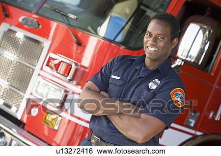 Fireman standing in front of fire engine View Large Photo Image Stock Photograph - Fireman standing in front of fire engine. Fotosearch