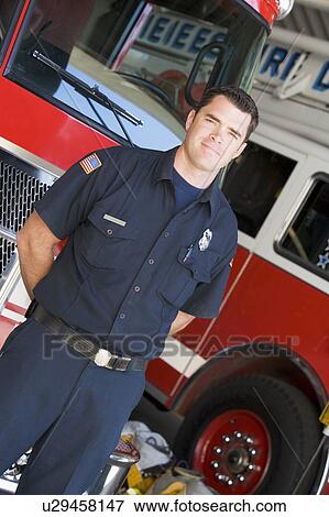 Fireman standing in front of fire engines View Large Photo Image Stock Photo - Fireman standing in front of fire engines. Fotosearch