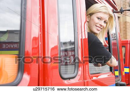 Firewoman sitting in fire engine with head out window View Large Photo Image Stock Photograph - Firewoman sitting in fire engine with head out window. Fotosearch