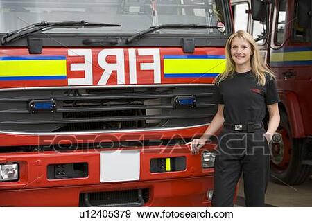Stock Photo - Firewoman standing in front of fire engine. Fotosearch