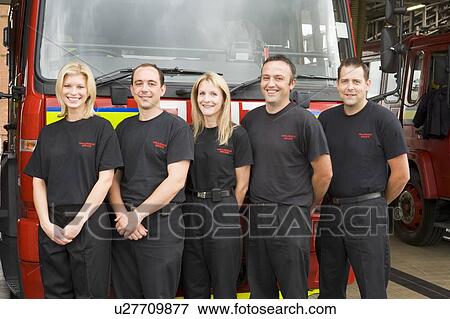 Stock Photo - Five firefighters standing in front of fire engine. Fotosearch