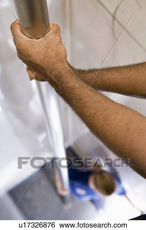 Stock Photograph - Shot of fireman's hands on a fire pole with firewoman at bottom (selective focus). Fotosearch