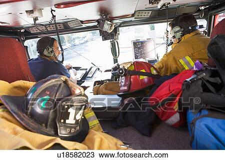Two firefighters driving a fire engine with gear in the back (selective focus) View Large Photo Image Stock Image - Two firefighters driving a fire engine with gear in the back (selective focus). Fotosearch