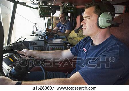 Two firemen in fire engine View Large Photo Image Stock Photo - Two firemen in fire engine. Fotosearch